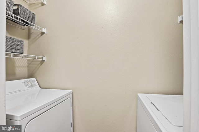 clothes washing area with separate washer and dryer and laundry area