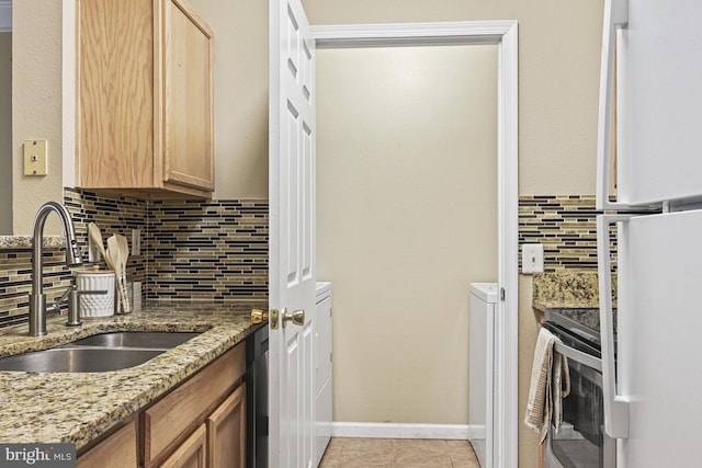 kitchen featuring light stone counters, light tile patterned floors, electric range, a sink, and tasteful backsplash