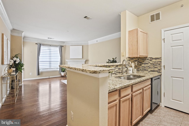 kitchen with tasteful backsplash, visible vents, light brown cabinets, and a sink