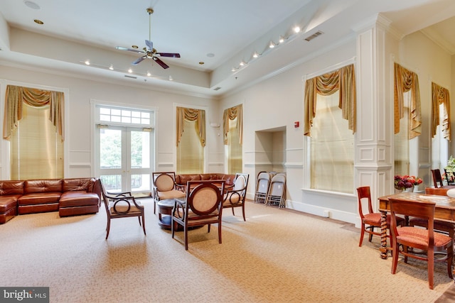 interior space featuring visible vents, crown molding, ceiling fan, a tray ceiling, and carpet flooring