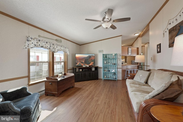 living room featuring vaulted ceiling, wood finished floors, and crown molding