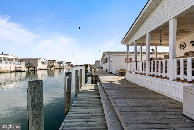 view of dock with a residential view and a water view