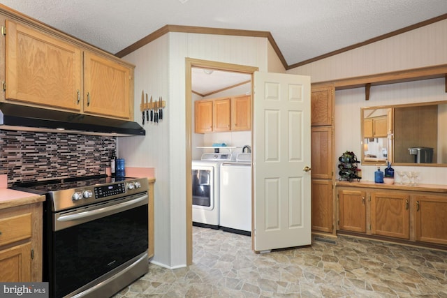 kitchen with electric range, ornamental molding, under cabinet range hood, stone finish flooring, and washer and dryer