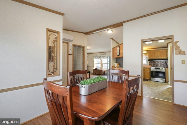 dining space with crown molding and wood finished floors