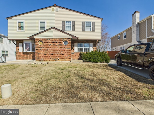 view of front of home with brick siding and a front yard