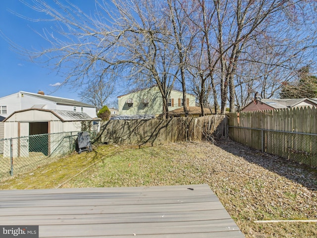 view of yard with a storage shed, a fenced backyard, and an outdoor structure