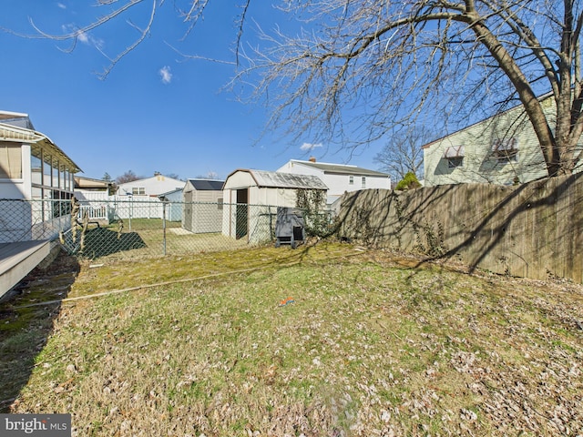 view of yard featuring an outbuilding, a storage shed, and a fenced backyard