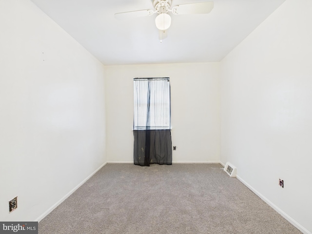 empty room featuring baseboards, carpet floors, visible vents, and ceiling fan