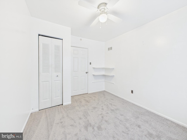 unfurnished bedroom featuring visible vents, ceiling fan, baseboards, carpet floors, and a closet