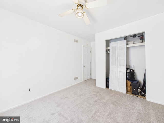 unfurnished bedroom with a closet, visible vents, carpet flooring, and ceiling fan