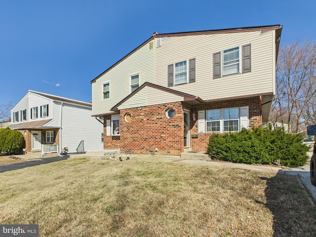 back of house featuring a yard and brick siding