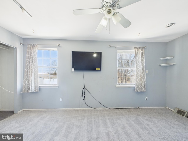 unfurnished living room with plenty of natural light, visible vents, and carpet floors