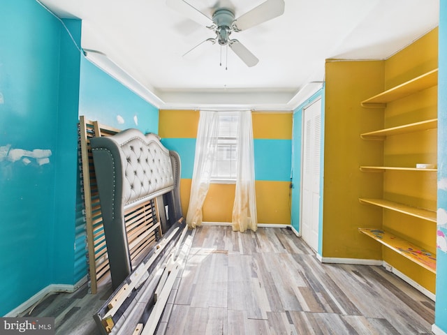 unfurnished bedroom with a ceiling fan, baseboards, and wood finished floors