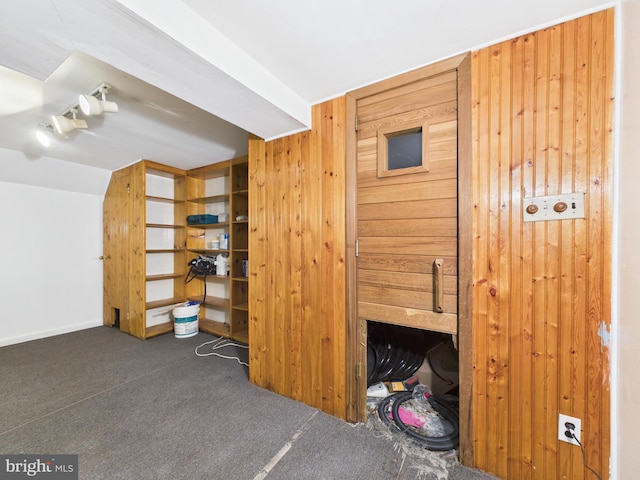 interior space with carpet floors, wooden walls, and a fireplace