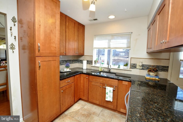 kitchen with visible vents, tasteful backsplash, and brown cabinetry