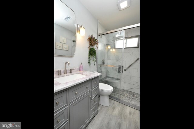 full bathroom featuring visible vents, a stall shower, toilet, and vanity