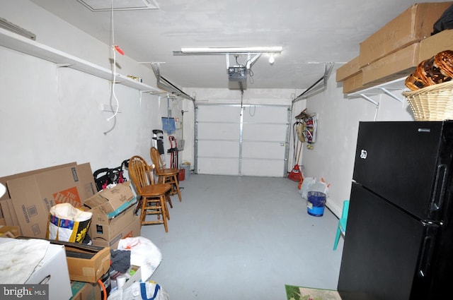 garage featuring a garage door opener and freestanding refrigerator