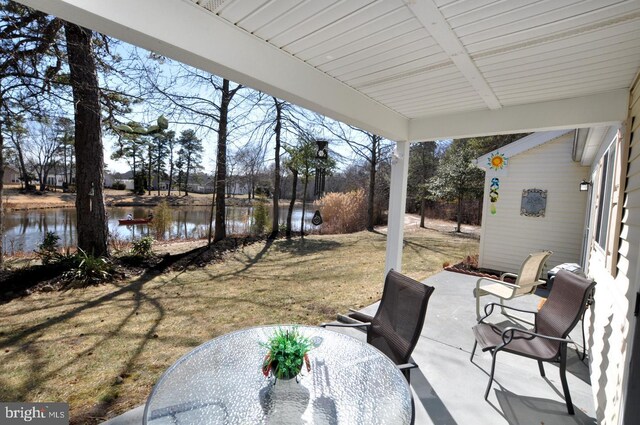 view of patio featuring a water view and outdoor dining space