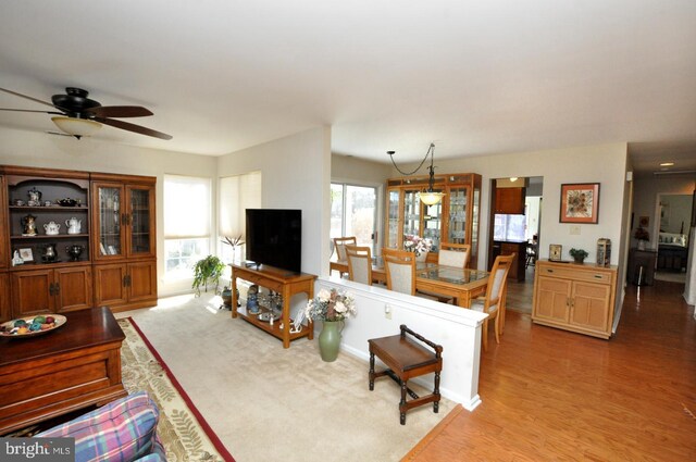 living area with light wood-type flooring and ceiling fan