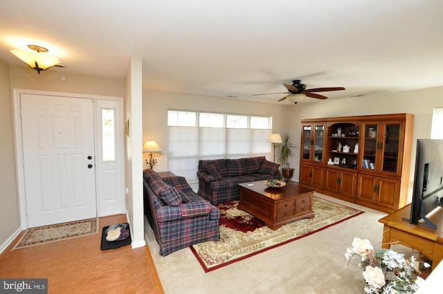 living room with baseboards and ceiling fan