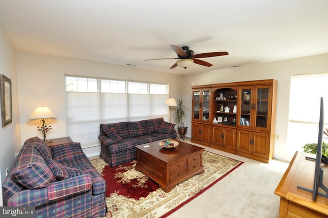 living area featuring a ceiling fan and carpet