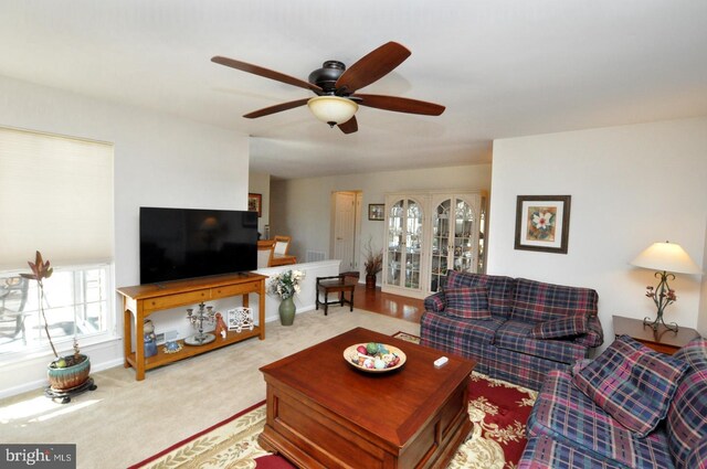 living room with baseboards, carpet floors, and ceiling fan