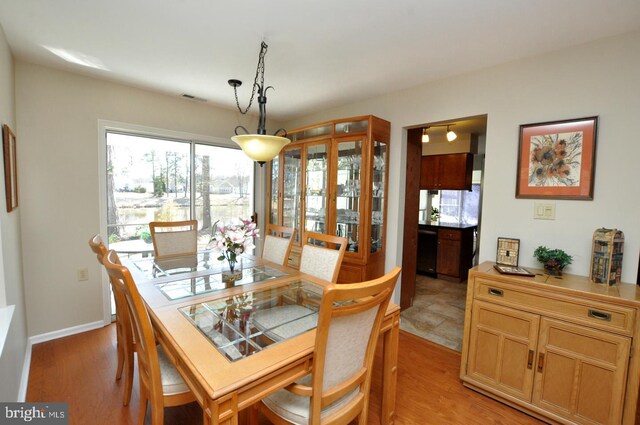 dining area featuring visible vents, light wood-type flooring, and baseboards