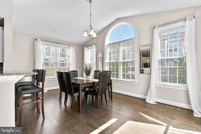 dining area with visible vents, dark wood-type flooring, a notable chandelier, baseboards, and vaulted ceiling