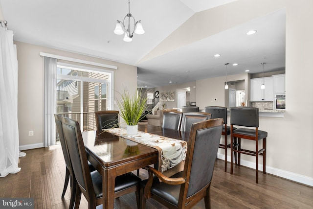 dining area featuring dark wood-style floors, a chandelier, baseboards, and vaulted ceiling