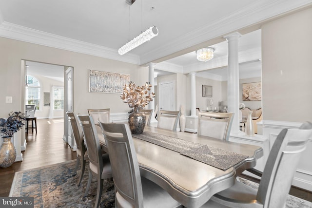 dining room with ornamental molding, ornate columns, and wood finished floors