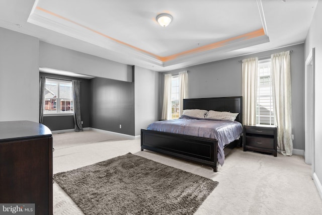 bedroom featuring a tray ceiling, baseboards, and carpet flooring