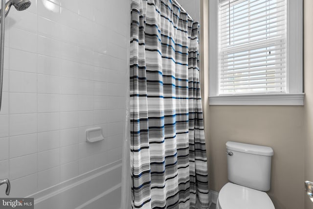 bathroom featuring a shower with shower curtain and toilet