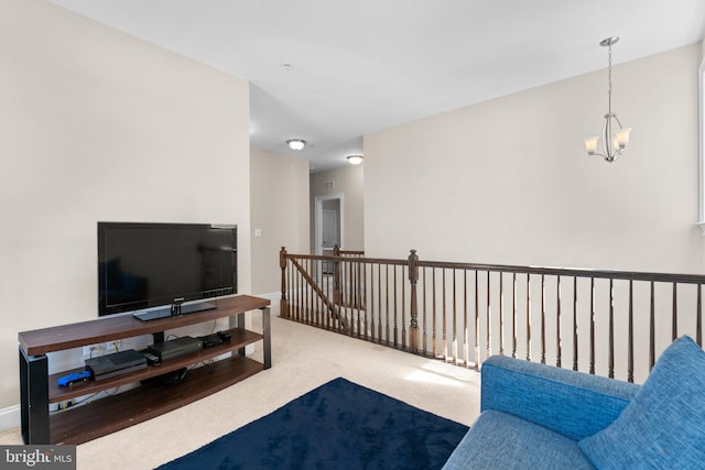 carpeted living area featuring an inviting chandelier