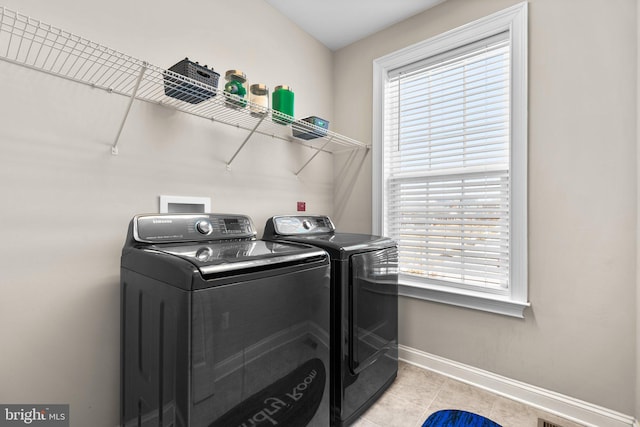 washroom with laundry area, separate washer and dryer, baseboards, and a wealth of natural light