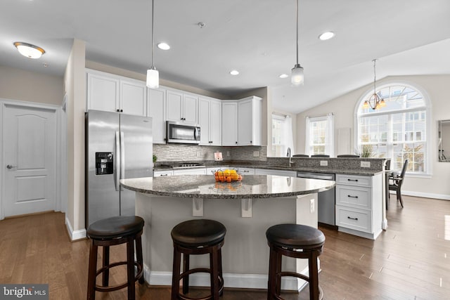 kitchen featuring tasteful backsplash, appliances with stainless steel finishes, a peninsula, and white cabinetry