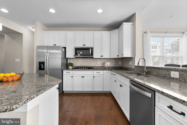 kitchen featuring a sink, tasteful backsplash, dark wood-style floors, appliances with stainless steel finishes, and stone counters