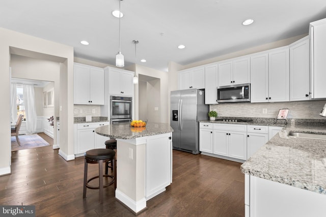 kitchen featuring tasteful backsplash, appliances with stainless steel finishes, dark wood finished floors, and white cabinets