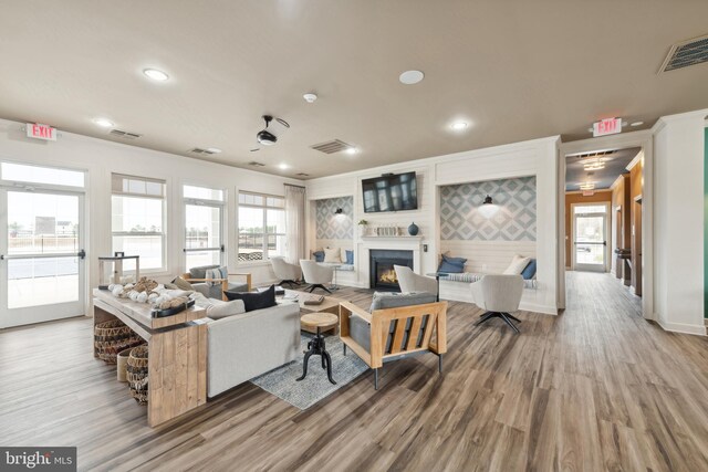 living room featuring visible vents, wood finished floors, and a glass covered fireplace