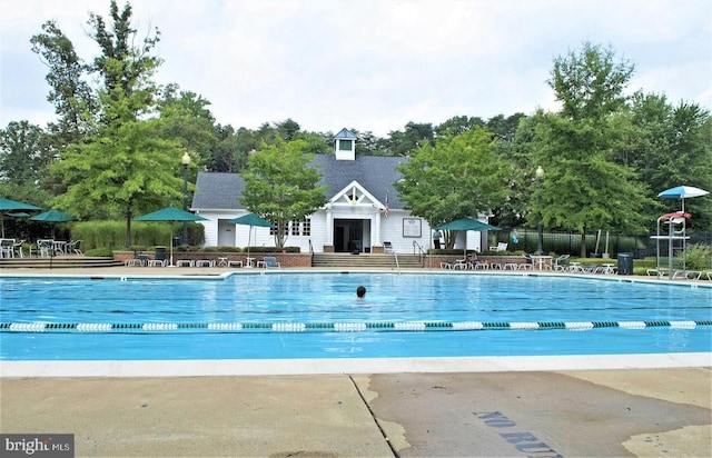 pool with a patio and fence