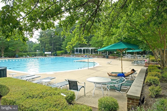 pool with a patio and fence