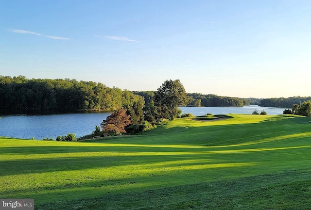 surrounding community featuring a lawn, view of golf course, and a water view