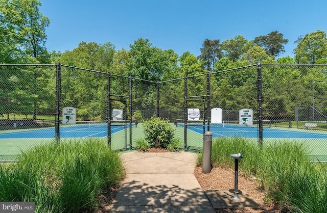 view of tennis court featuring fence and a gate