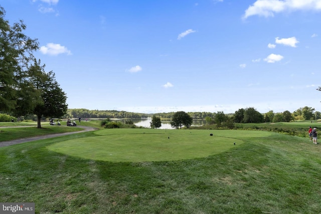 view of property's community featuring golf course view, a lawn, and a water view