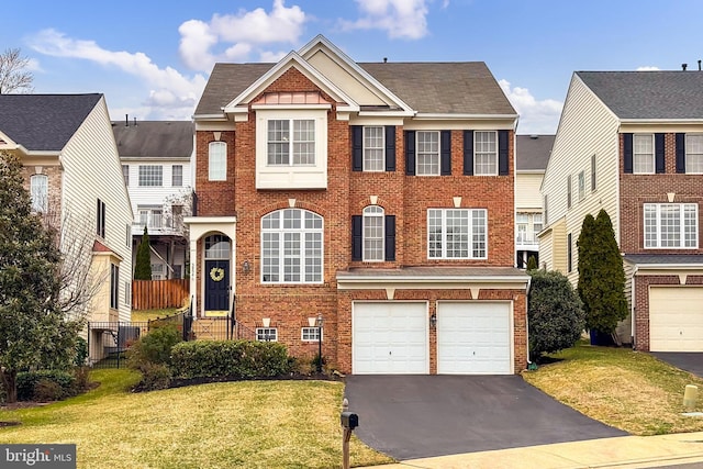 view of front facade with a front lawn, driveway, roof with shingles, an attached garage, and brick siding