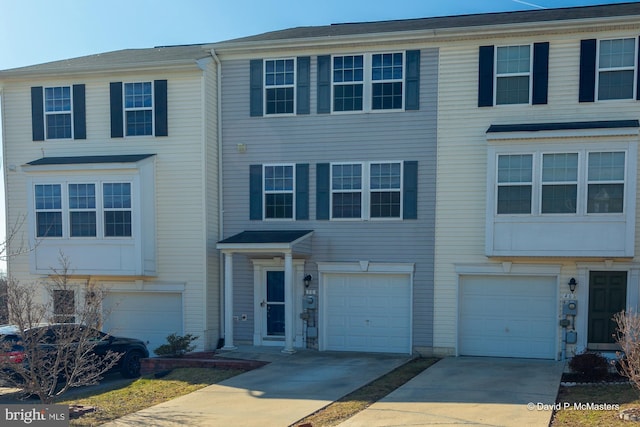 view of property featuring concrete driveway and an attached garage