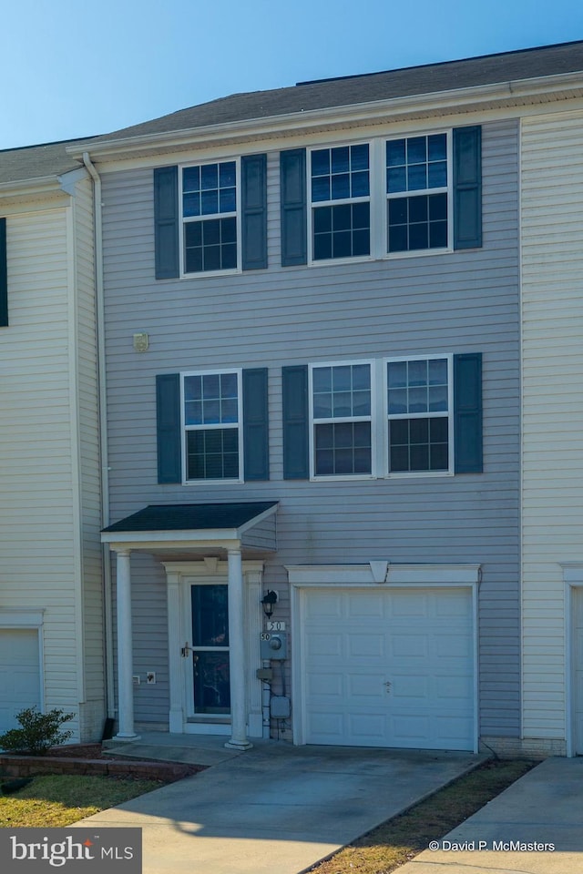 multi unit property featuring an attached garage and driveway