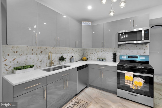 kitchen with a sink, stainless steel appliances, marble finish floor, and gray cabinetry