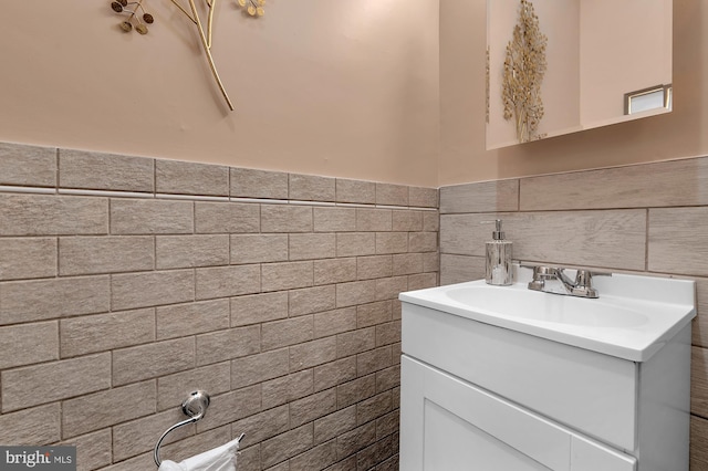 bathroom with tile walls, wainscoting, and vanity