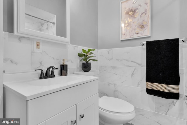 bathroom featuring vanity, tile walls, toilet, and marble finish floor