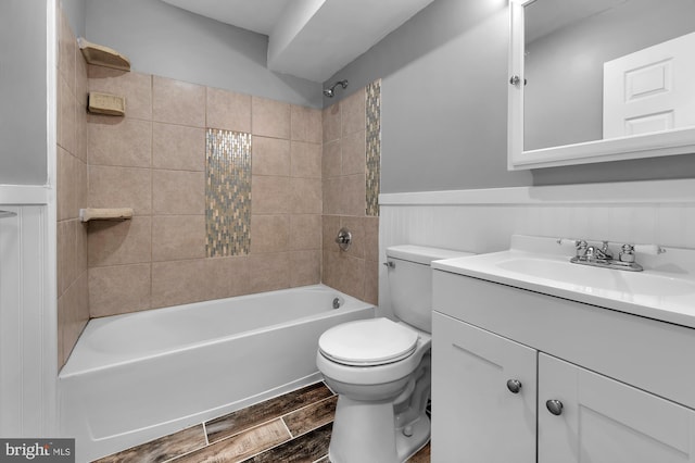 bathroom featuring toilet, wood tiled floor, shower / bathing tub combination, wainscoting, and vanity